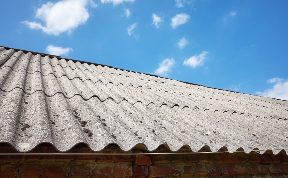 Toiture en plaques ondulées de fibrociment sous un ciel bleu