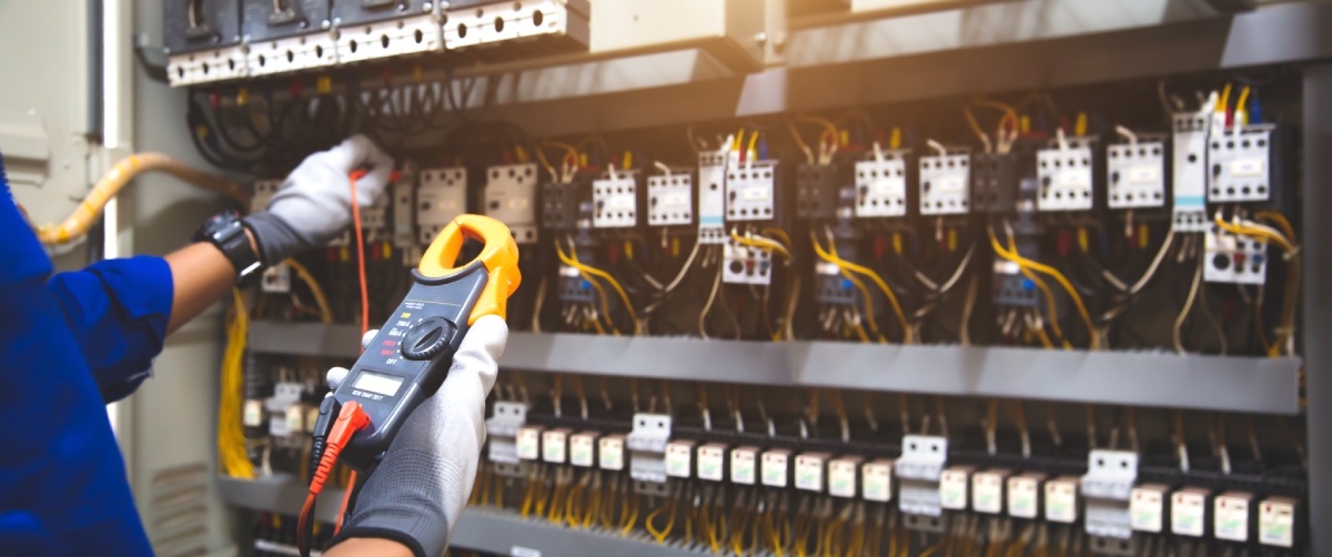 Électricien testant un tableau électrique avec un multimètre