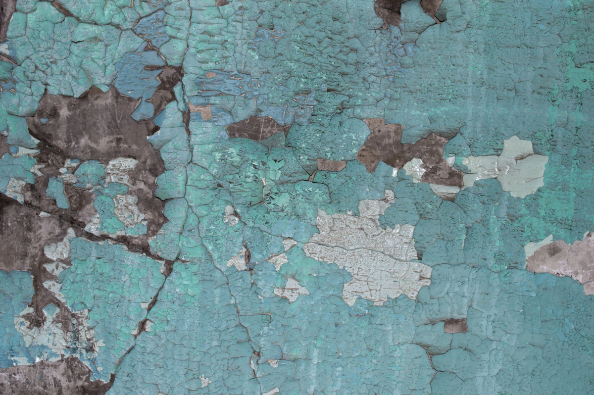 Mur à peinture turquoise écaillée illustrant un diagnostic plomb